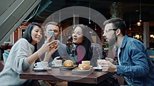 Modern young people taking pictures of food and drinks then sharing photos laughing in cafe