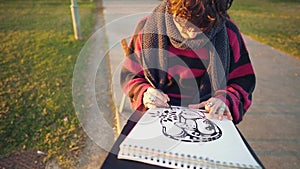 Modern young stylish male paint artist drawing sketches in park