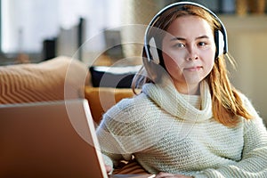 Modern young woman listening to music while and laptop