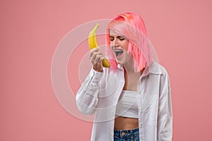 Modern young woman performing a song with a fruit mike