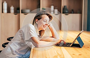 Modern young woman surfing the internet on a computer tablet while sitting in a coworking space.