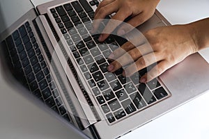 Modern young woman working at home as a freelancer. Close up view of white female hands typing on a laptop keyboard. Millennial