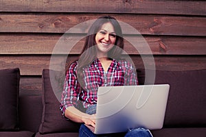 Modern youth using silver laptop while sitting intdoors on the s