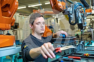 Modification of the robot to produce a new product. technically, the worker adjusts the machine. concept industry 4.0