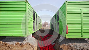 Modular bitcoin mining farm construction site. ASIC mining equipment in green steel shipping containers. Installing