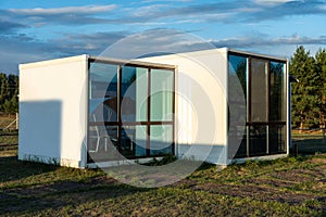 Modular frame house with panoramic windows on the edge of a pine forest