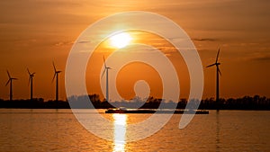 Moerdijk Netherlands, sunset winth windmills by the lake Vokerak river in Holland windmill energy sunset