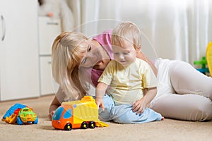 Moher and her toddler son plays with car toys in his cosy childrem room