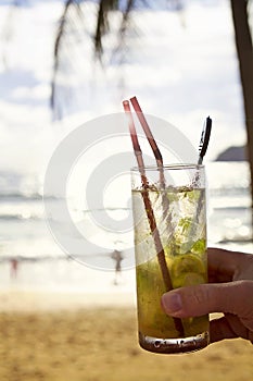 Mohito cocktail with sun flare at the beach