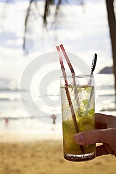 Mohito cocktail with sun flare at the beach