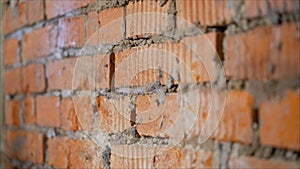 He moistening the surface before applying plaster. The process of priming a brick wall. A primer solution is applied to a brick