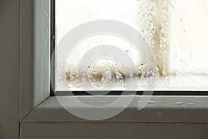 Moisture and condensation on the window in the apartment, water on the glass close-up