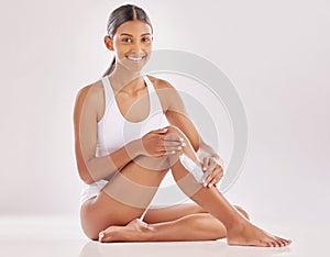 Moisturise and show them off. a young woman applying moisturizer to her legs. photo