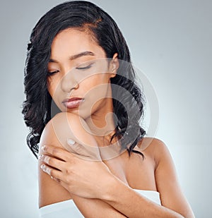 Moisturise your hair and body regularly. Studio shot of an attractive young woman posing against a grey background. photo