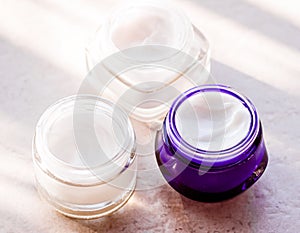 Moisturising beauty cream jars, skincare and spa cosmetics on stone background in summer at sunset, cosmetic product and skin care