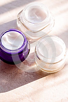 Moisturising beauty cream jars, skincare and spa cosmetics on stone background in summer at sunset, cosmetic product and skin care