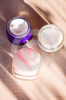 Moisturising beauty cream jars, skincare and spa cosmetics on stone background in summer at sunset, cosmetic product and skin care