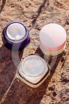 Moisturising beauty cream jars, skincare and spa cosmetics on stone background in summer at sunset, cosmetic product and skin care