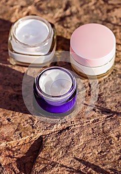 Moisturising beauty cream jars, skincare and spa cosmetics on stone background in summer at sunset, cosmetic product and skin care