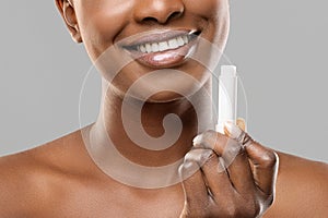 Moisturising lip balm in hands of unrecognizable african american woman