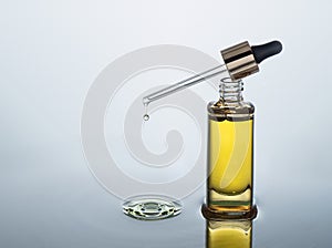 Moisturizing cosmetic oil stands on the dark water background with splash