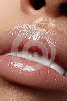 Moisturizing lip balm, lipstick. Close-up of a beautiful wet lips. Full lips with gloss makeup. Filler Injections