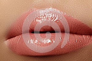 Moisturizing lip balm, lipstick. Close-up of a beautiful wet lips. Full lips with gloss makeup. Filler Injections