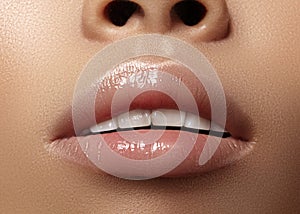 Moisturizing lip balm, lipstick. Close-up beautiful wet lips. Full lips with gloss lip makeup. Filler Injections