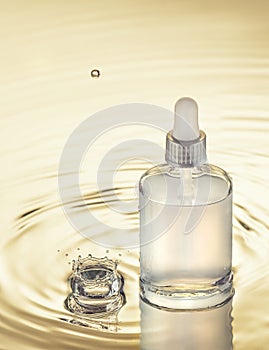 Moisturizing serum on the yellow water background with splash and drop