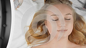 Moisturizing skin face and eyelids. Cosmetology for women: eyelash extension procedure in modern beauty salon. In fat