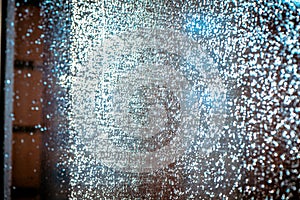 Wet Window glass after heavy rain lit by the setting sun. Abstract blurred background, Selective soft focus photo