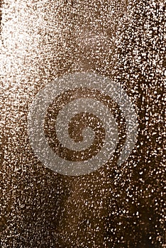 Moisty wet window with water running down the surface. Glass after heavy rain lit by setting sun. Selective soft focus photo