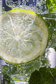 Mojito alcoholic cocktail, rum with mint ice, lime and tonic, close-up,