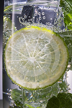 Mojito alcoholic cocktail, rum with mint ice, lime and tonic, close-up,