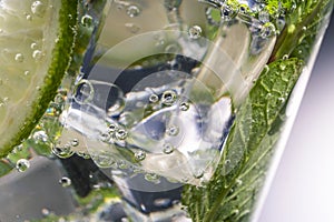 Mojito alcoholic cocktail, rum with mint ice, lime and tonic, close-up,