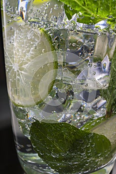 Mojito alcoholic cocktail, rum with mint ice, lime and tonic, close-up,