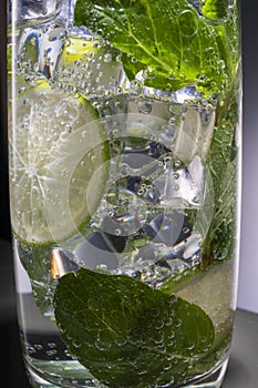 Mojito alcoholic cocktail, rum with mint ice, lime and tonic, close-up,