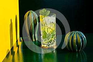Mojito alcoholic cocktails with alcohol, rum lime, mint and ice with hard lights on colorful background. Mixology details and