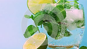 Mojito alcoholic drink on a wooden tray, close-up fresh drink, bubbles in a glass, studio shock of fruit drink with mint and lime