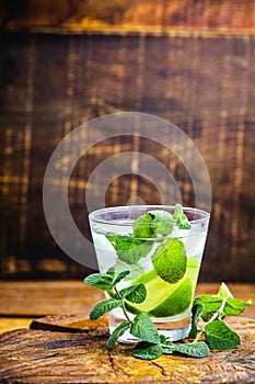 Mojito cocktail at the bar. Mojito cocktail over rustic wood. Cold Mojito, rum, lime and mint tourist drink