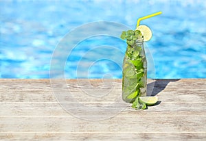 Mojito cocktail at the edge of a resort pool. Concept of luxury vacation