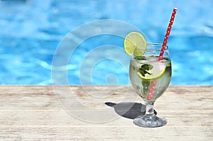 Mojito cocktail at the edge of a resort pool. Concept of luxury vacation