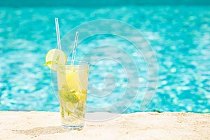 Mojito cocktail at the edge of a resort pool. Concept of luxury