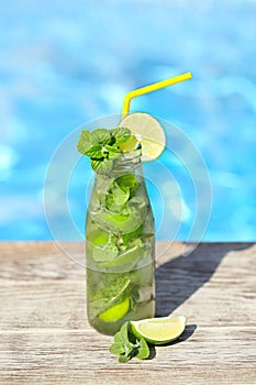 Mojito cocktail at the edge of a resort pool. Concept of luxury vacation