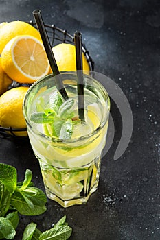 Mojito cocktail or lemonade with lime and mint in highball glass on black. Summer drink