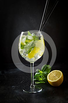 Mojito cocktail or lemonade with mint in glass on black. Close up. Summer drink