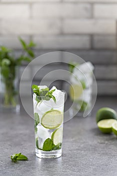Mojito cocktail with lime and mint in glass. Mojito cocktail on dark stone table