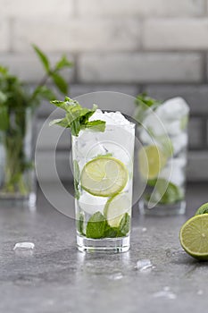 Mojito cocktail with lime and mint in glass. Mojito cocktail on dark stone table