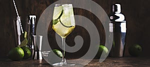 Mojito cocktail with lime and mint in wine glass on wooden background. Panoramic banner with copy space