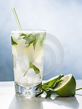 Mojito cocktail with lime, sugar, ice and mint leaves in the gray background. photo